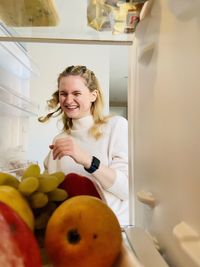 Portrait of cute girl holding fruits at home