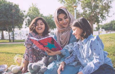 Rear view of smiling girl sitting outdoors