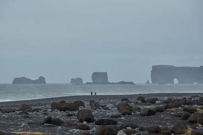 Rocks on beach against sky