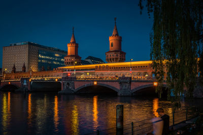 Illuminated bridge over river at night