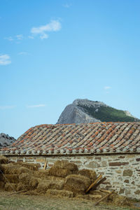Old house on mountain against sky