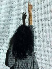 Rear view of woman standing against wall