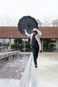 Full length of man standing on snow during rainy season