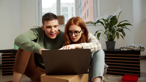 Young couple using laptop at home