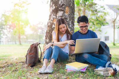 University students using laptop at park