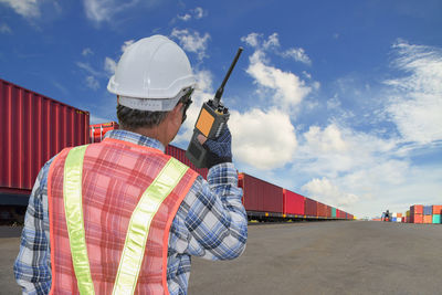 Rear view of man working against sky