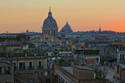 Buildings in city against sky during sunset