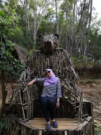 Rear view of man sitting on seat in forest