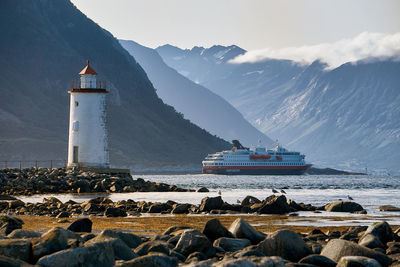 Hurtigruten passing høgsteinen lighthouse before entering the fjords, godøy, norway
