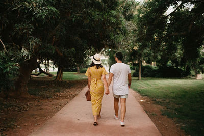 Rear view of couple walking on footpath