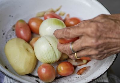 Cropped image of person holding fruits in plate