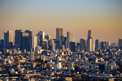 Modern buildings in shinjuku city against sky during sunset