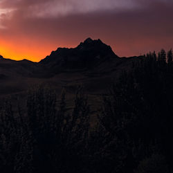 Scenic view of silhouette mountains against sky at sunset