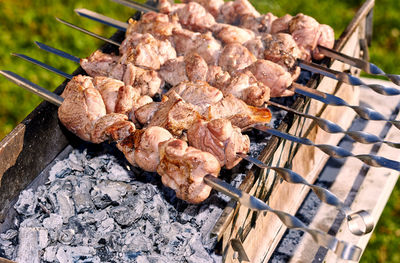 High angle view of meats in skewers on barbecue at back yard