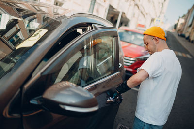 Midsection of man standing by car