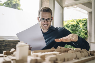 Smiling architect looking at urban development model