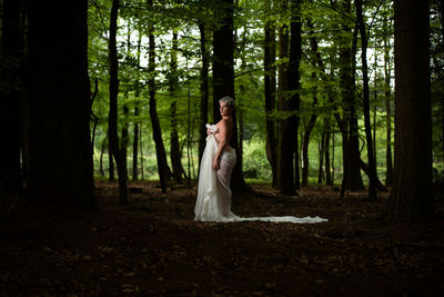 Full length of woman standing in forest