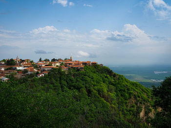 Scenic view of townscape by sea against sky