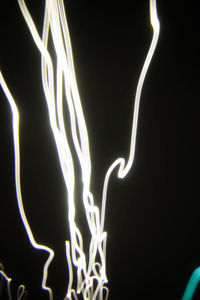 Close-up of illuminated light bulb against black background