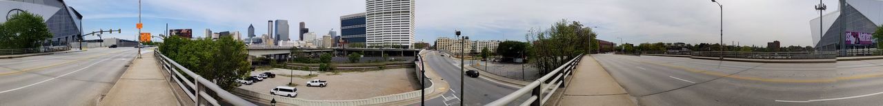 Panoramic view of city street and buildings against sky