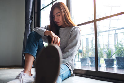 A sad and stressed young asian woman sitting alone in the room