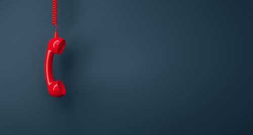 Close-up of red telephone pole against black background