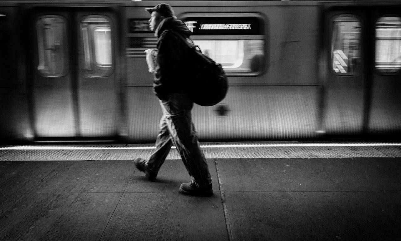 transportation, mode of transportation, one person, real people, train, rail transportation, public transportation, blurred motion, train - vehicle, travel, motion, full length, railroad station, railroad station platform, indoors, rear view, lifestyles, architecture, subway train, waiting
