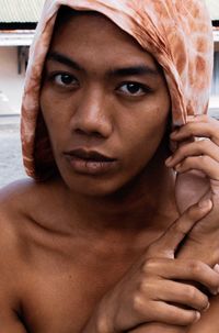 Close-up portrait of shirtless young man wearing headscarf