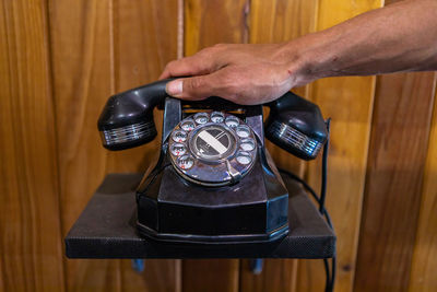 Close-up of hand holding smart phone on table