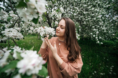 Beautiful young girl in the garden of blooming apple trees
