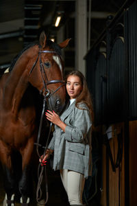 Young woman wearing hat in stable