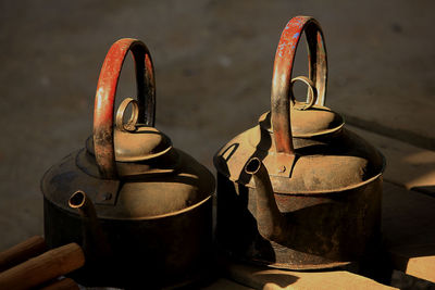 Close-up of old kettles on table
