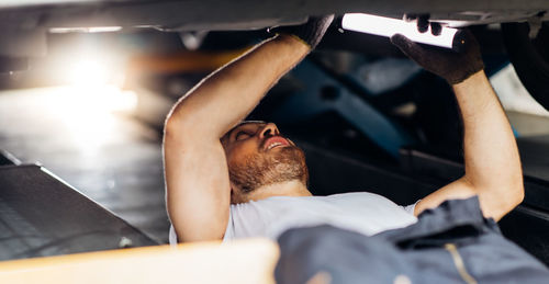 Midsection of man lying down in car