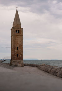 Historic building by sea against sky
