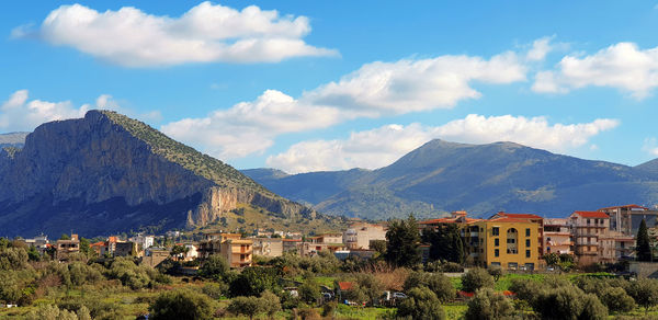 Townscape by mountains against sky