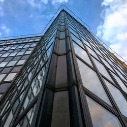 Low angle view of glass building against sky