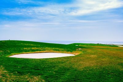 High angle view of golf course on field against sky