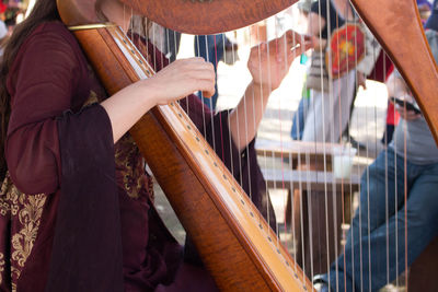 Midsection of woman playing string instrument