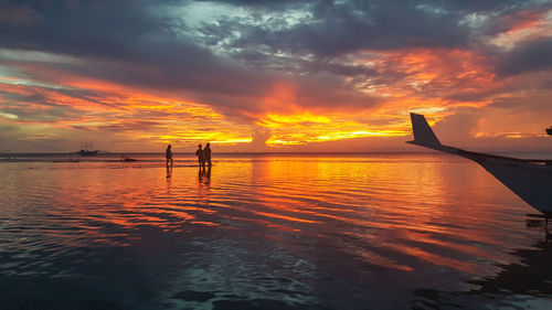 Silhouette boat in sea against sky during sunset