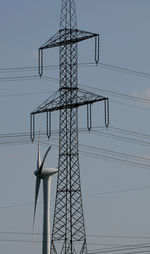 Low angle view of electricity pylon against clear sky