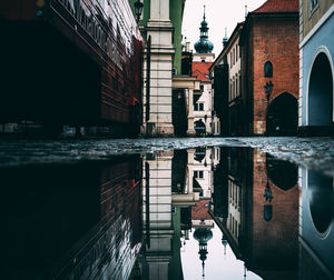 Buildings reflecting on puddle during rainy season