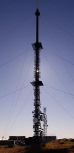 Low angle view of cranes against sky at dusk