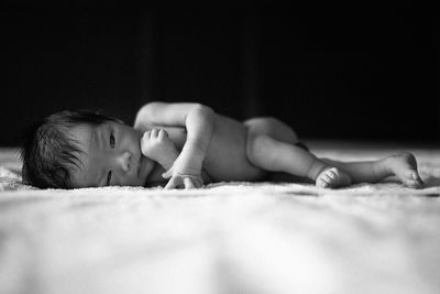 Close-up of baby boy lying on bed at home