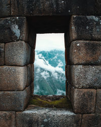 View of stone wall through window