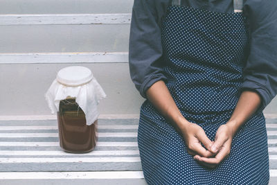 Midsection of woman standing against wall