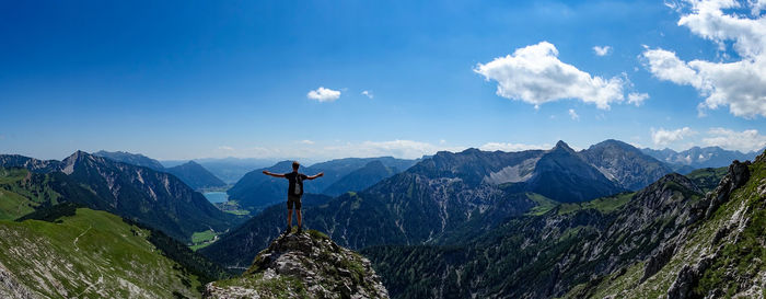 Rear view of boy standing on mountain against sky