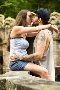 Side view of couple romancing on wall