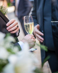 Midsection of man holding champagne