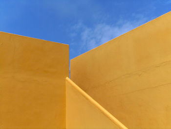 Low angle view of yellow wall against sky