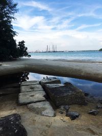 Scenic view of beach against cloudy sky